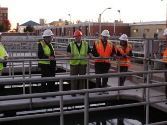 City council members in hard hats touring water plant