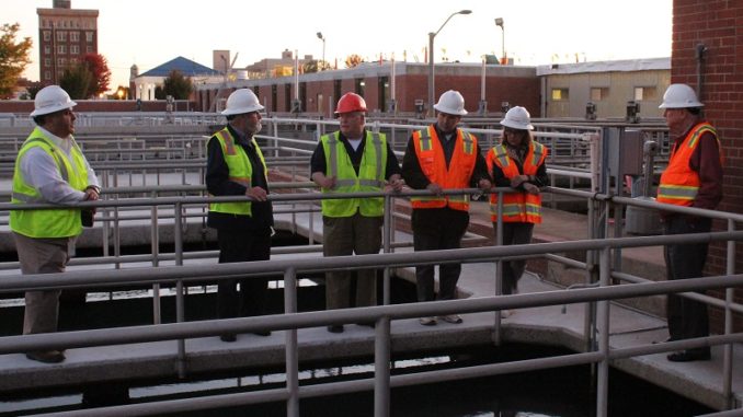 City council members in hard hats touring water plant