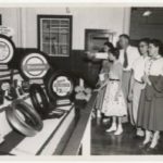 Five people looking at a display of tires