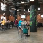 People eating and drinking at Growler USA in former Loray Mill