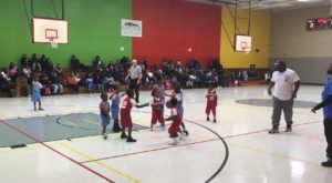 About nine very young children playing basketball