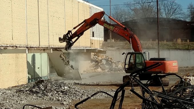 Equipment demolishing the side of a building