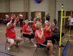 Older adults sitting on chairs playing volleyball