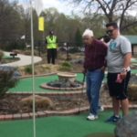 Two men on putting green at miniature golf