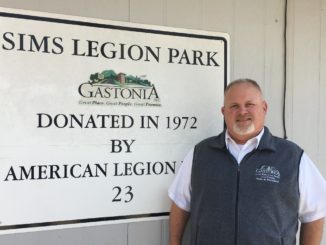 Cam Carpenter stands next to Sims Legion Park sign