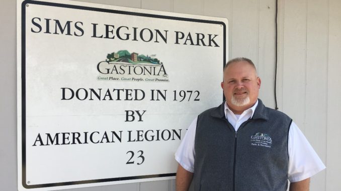 Cam Carpenter stands next to Sims Legion Park sign