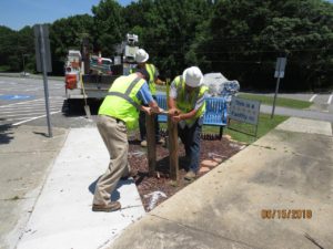 Men in hard hats installing posts into ground