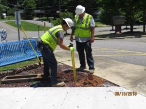 Men in hard hats digging post holes