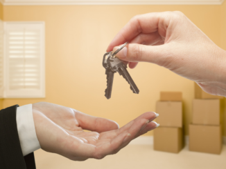 Two hands exchanging keys representing a new homebuyer