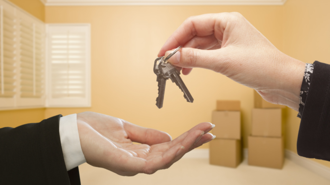 Two hands exchanging keys representing a new homebuyer