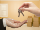 Two hands exchanging keys representing a new homebuyer