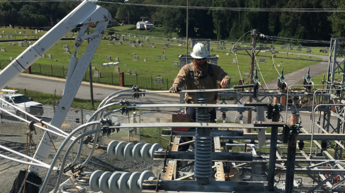 Man wearing hardhat repairing electric substation