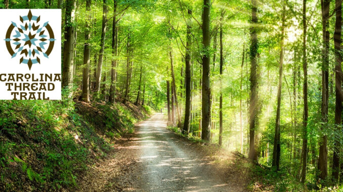 Path through wooded area with Carolina Thread Trail logo