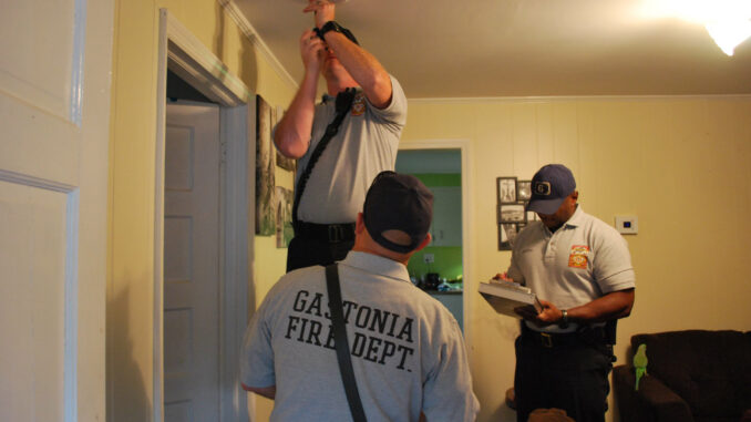 Firefighters installing smoke detector