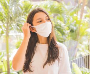 Young woman wearing a white face mask