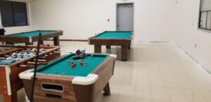 Pool tables in room with old flooring