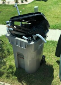 Dismantled lawn chair in recycle bin