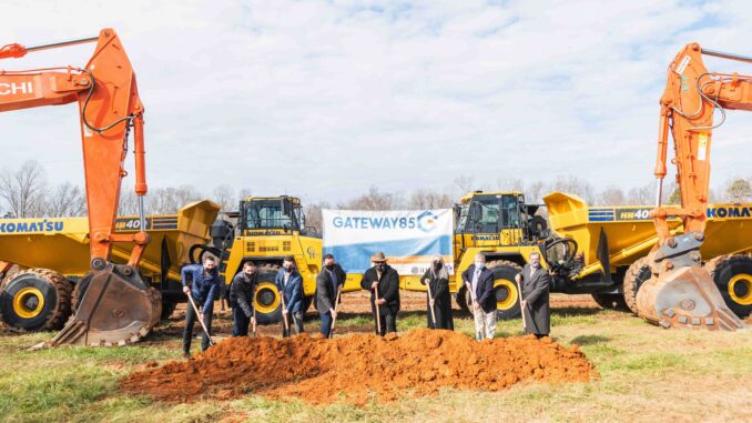 Gastonia City Councilmembers with shovels and dirt in front of heavy equipment