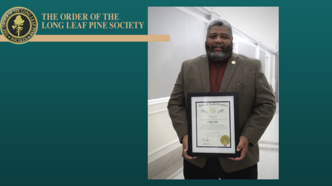 Mayor Walker Reid holding the Long Leaf Pine plaque