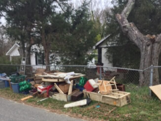 Discarded items piled at the edge of a yard