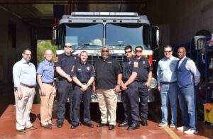 City officials and Fire Department employees in front of a firetruck