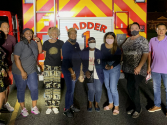 Nine members of Citizens Academy in front of the Ladder 1 firetruck