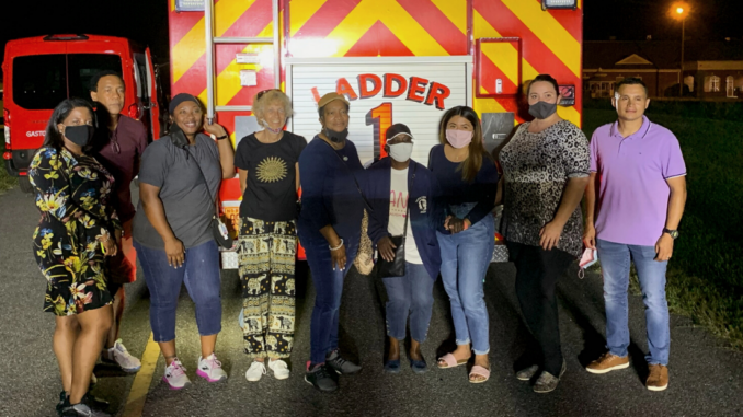 Nine members of Citizens Academy in front of the Ladder 1 firetruck