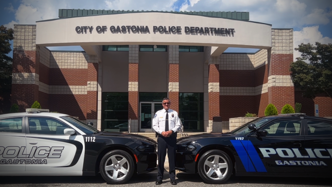 GPD Chief Brittain outside police headquarters with an old police cruiser and a new model of police car