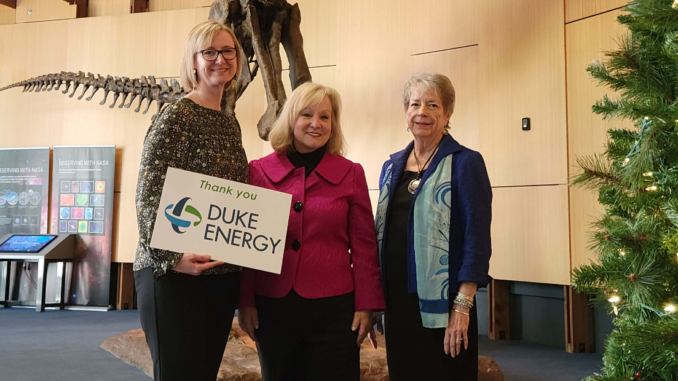 Schiele and Duke Energy employees with a sign that says Thank you Duke Energy.